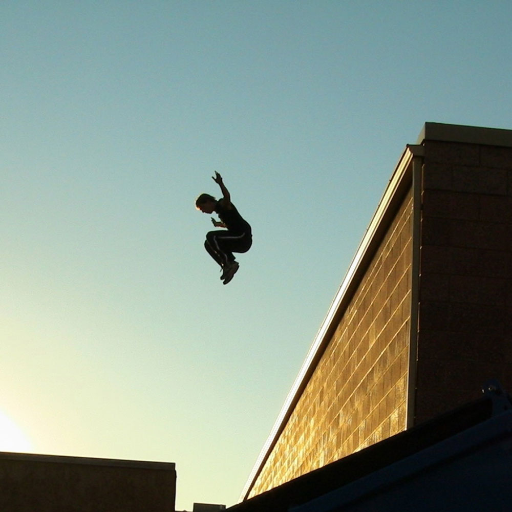 Questa immagine mostra un drop jump, un movimento di salto verso il basso. Il parkour è un'ottima forma di attività fisica e movimento, che pratico anch'io da fisioterapista.